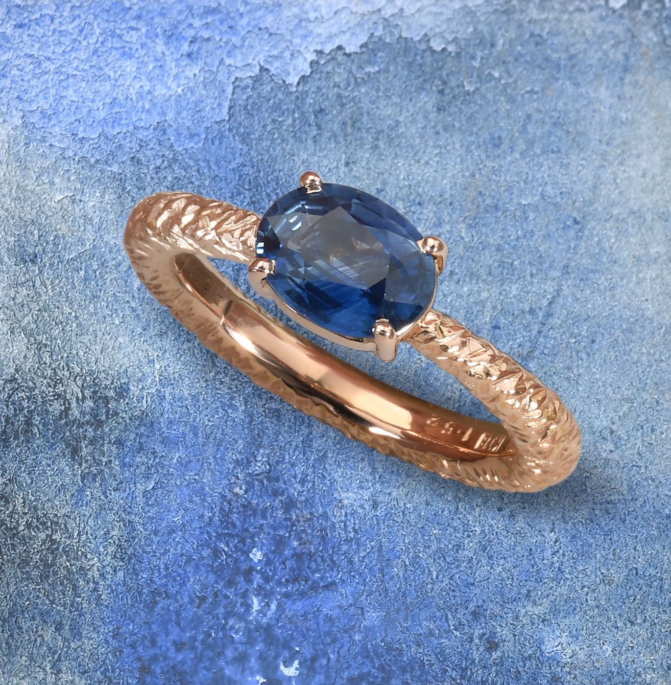 an 18k gold ring set with an oval blue sapphire