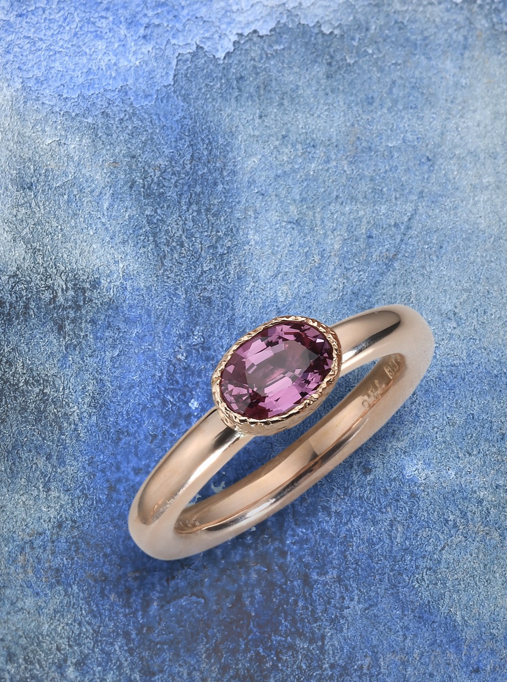 an 18k gold ring set with a pink sapphire