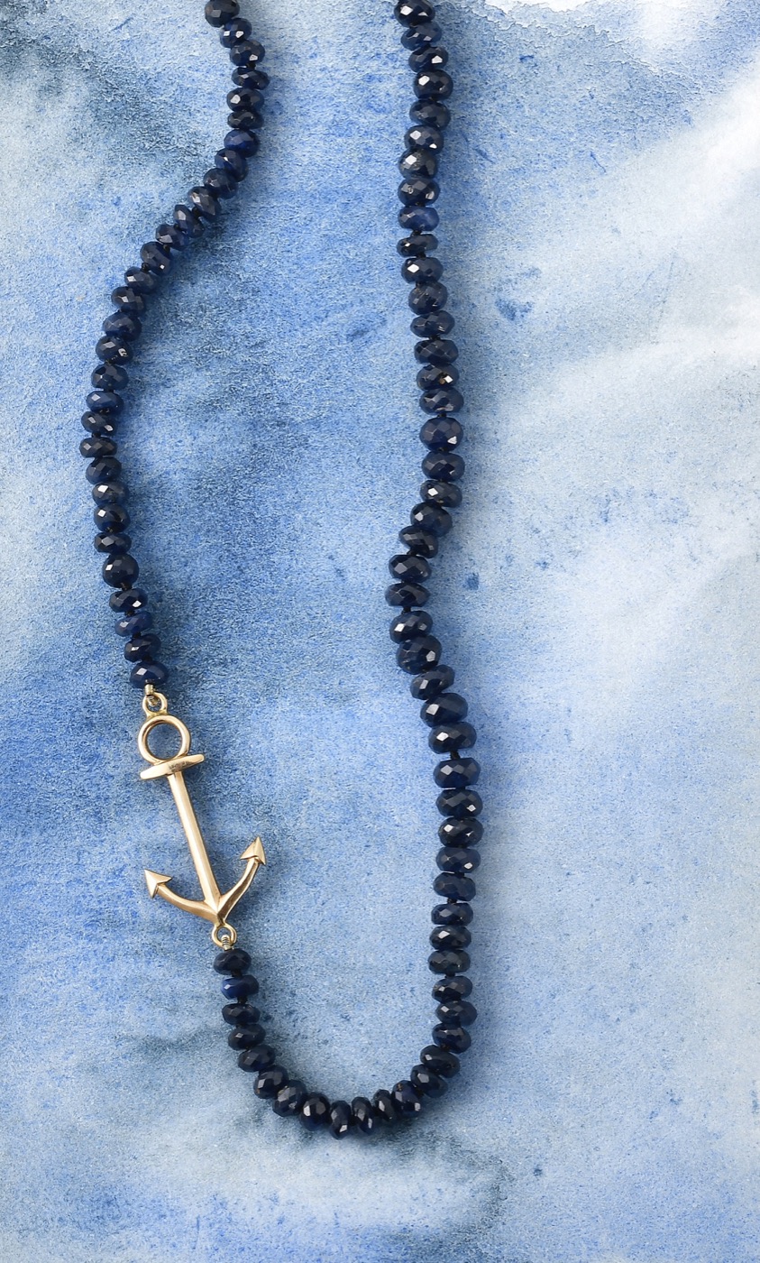 an 18k gold anchor charm necklace set with sapphires