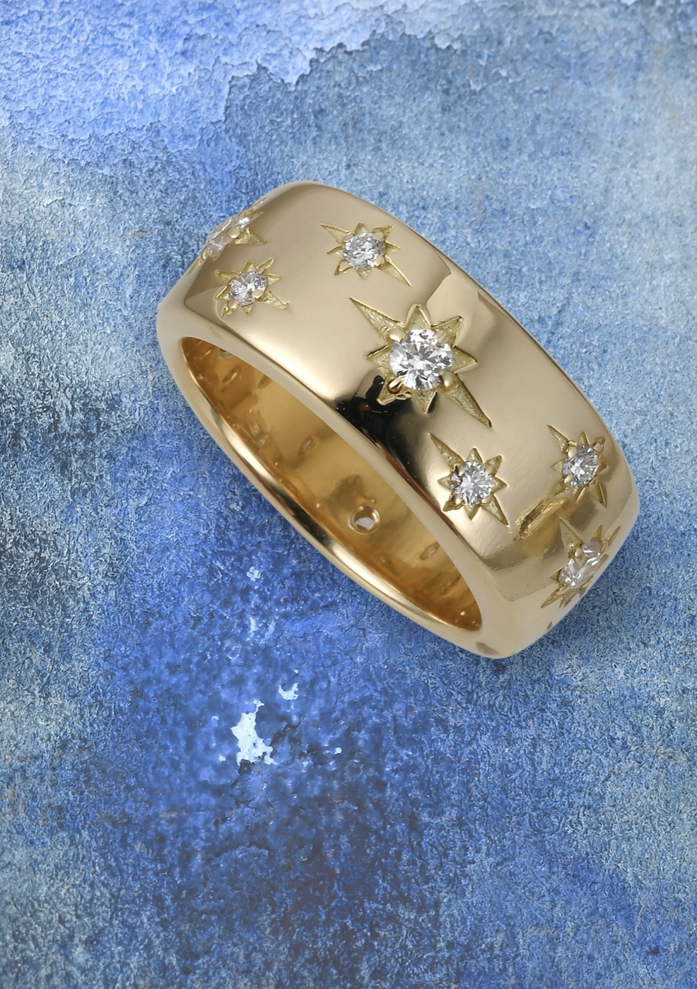 a wide 18k gold band set with diamond stars